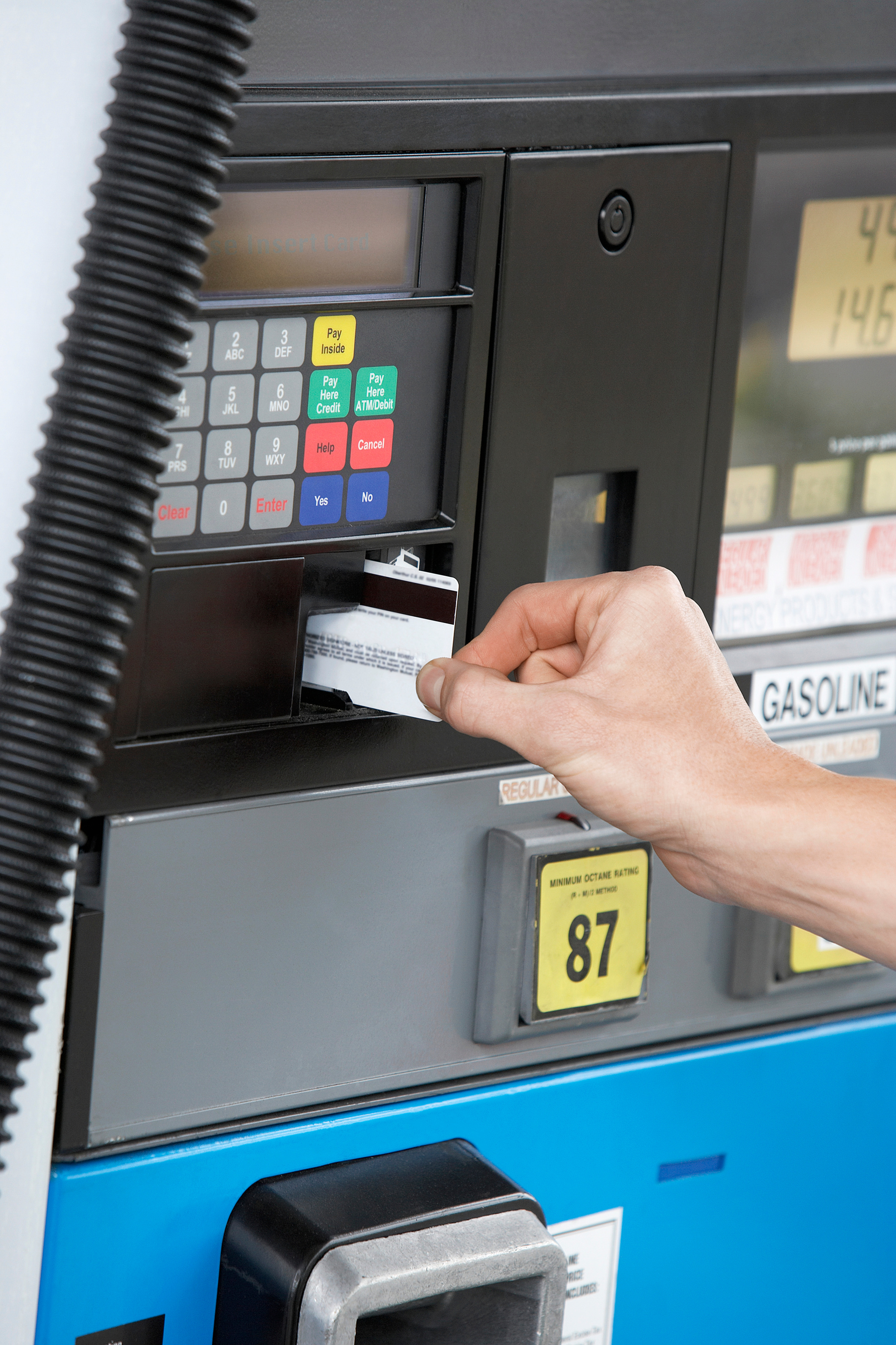 Person paying with credit card at gas pump close up of hand